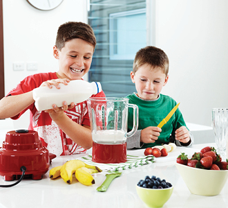 Two kids pouring milk for brekkie